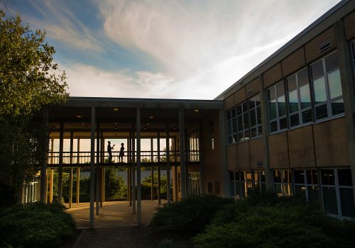 Phillips Hall with two people talking on the breezway